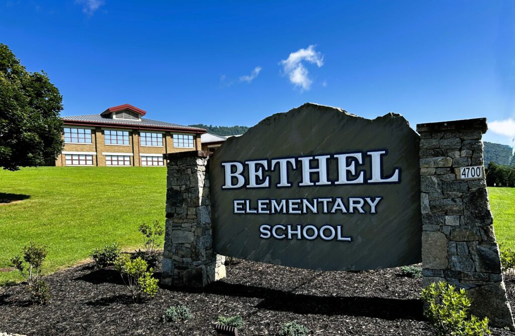 Photo of Bethel Elementary School sign with school in the background